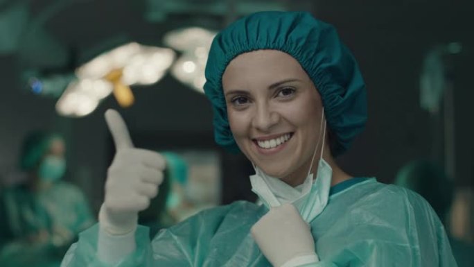 外科医生的女人表现出竖起大拇指的手势