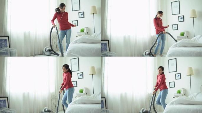 年轻女子玩得开心用吸尘器打扫房子