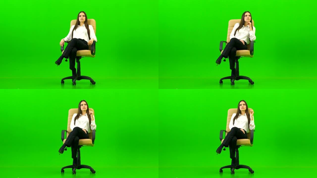 办公室椅子上的女人在绿色背景上说话