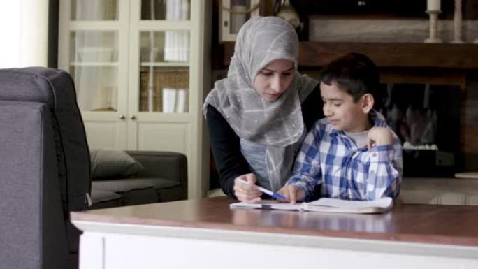 民族母亲帮助儿子做家庭作业