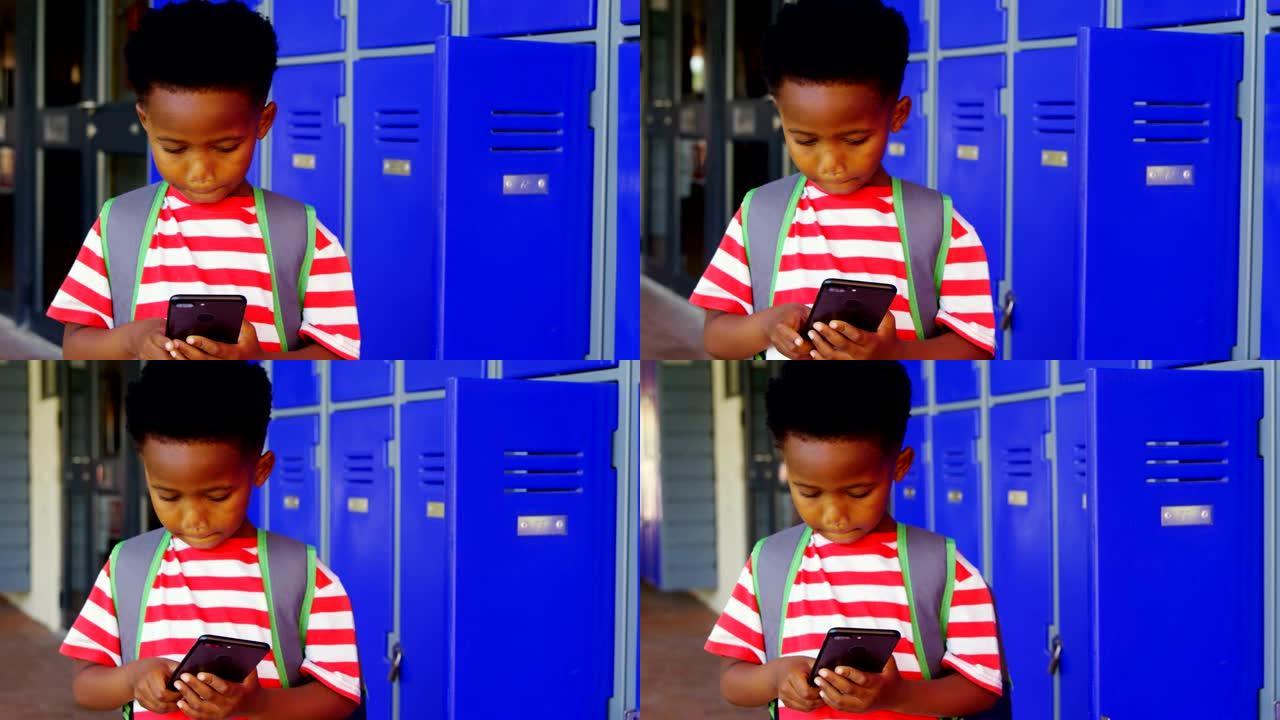 在学校走廊4k中使用手机的带书包的非洲裔美国小学生的前视图