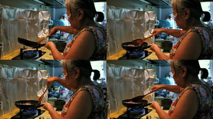 泰国高级妇女在家制作Pad Krapao。