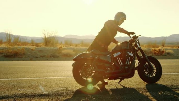 男子在日落前骑上全黑摩托车