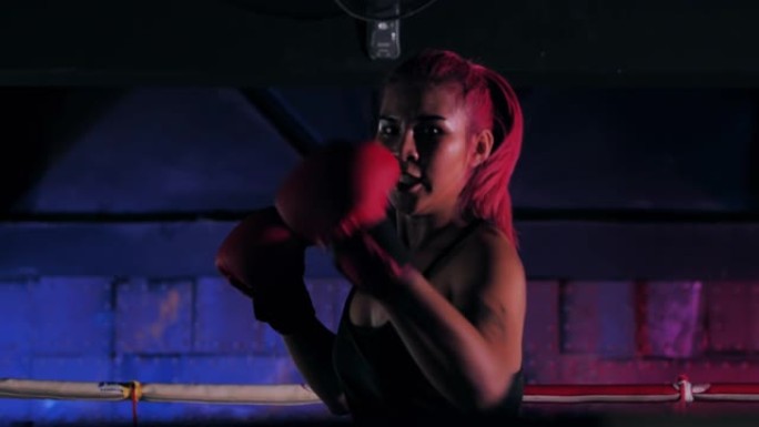 一名女拳击手在拳击场内拳打的特写镜头。拳击训练中的妇女。运动教练