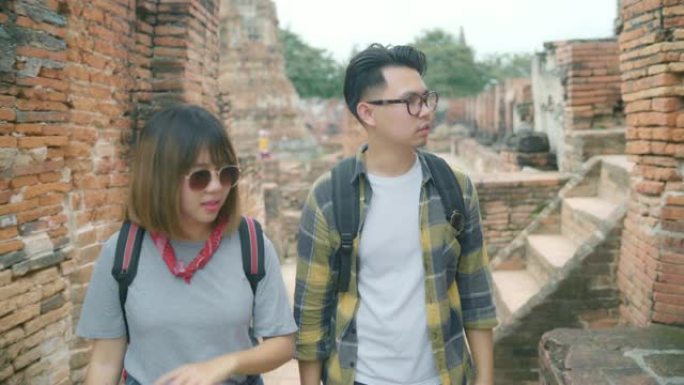 旅行者亚洲夫妇在泰国大城府度假旅行，背包客甜蜜夫妇在传统城市的惊人地标享受他们的旅程。生活方式夫妇旅