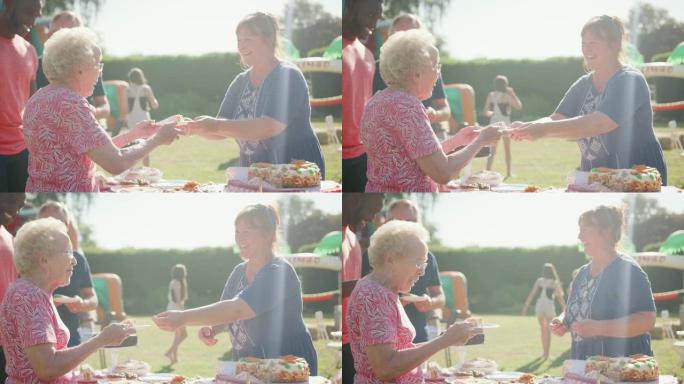 高级妇女在夏季花园的宴会上买蛋糕-慢动作拍摄