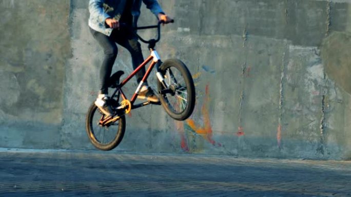 男子在滑板场用自行车做特技，慢动作。