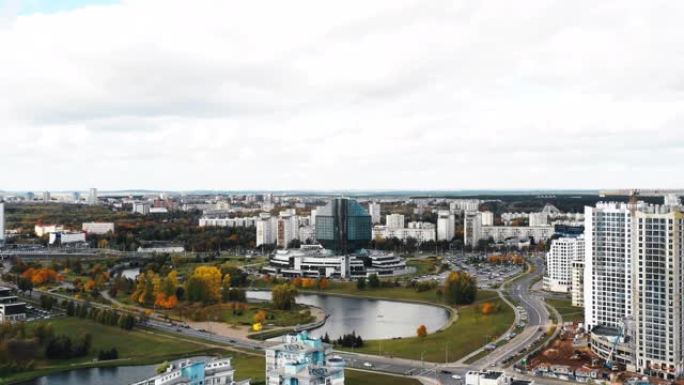 无人机飞越白俄罗斯明斯克美丽的秋季城市全景，靠近国家图书馆，道路和河流景观。