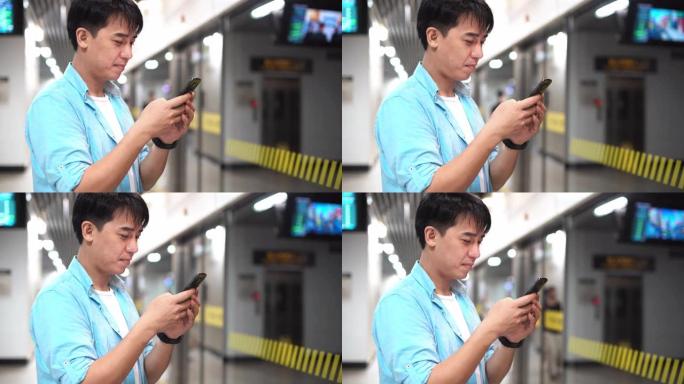 亚洲男子在地铁站使用手机