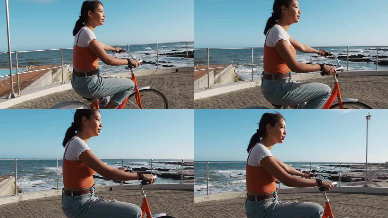 混血女孩骑自行车海边的侧视图