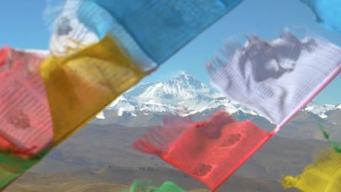 特写: 珠穆朗玛峰的壮丽景色在风中飘扬的模糊祈祷旗后面
