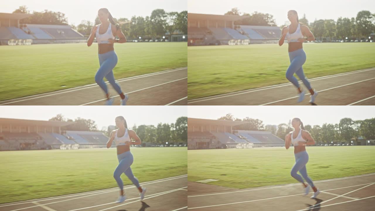 穿着浅蓝色运动上衣和打底裤的快乐微笑健身女子在体育场慢跑。在温暖的夏日，她跑得很快。运动员在做她的体
