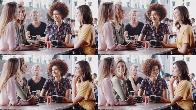 一群女性朋友在咖啡馆见面并坐在桌子旁聊天-慢动作拍摄