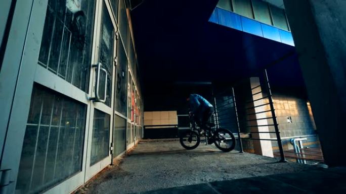 男少年在空荡荡的建筑物里骑自行车做特技