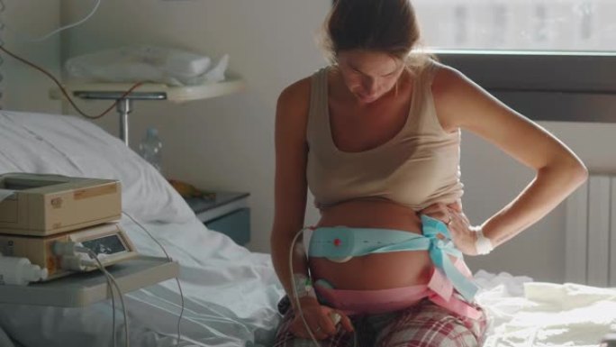 一名年轻孕妇的真实特写镜头在医院的产房分娩前几个小时发生宫缩