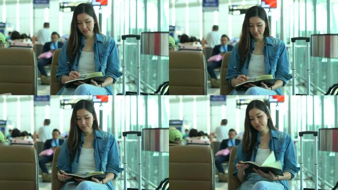 在航站楼机场的登机口，等待着的年轻休闲女子在笔记本上写了一个简短的便条。年轻女性独自乘飞机旅行。