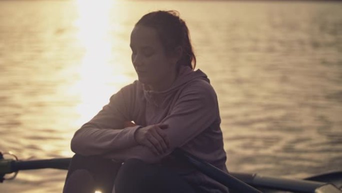 女人在日落时在河上的船上休息