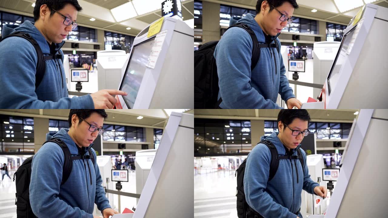 亚洲男子在机场用自助服务机办理登机手续