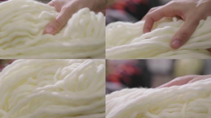 触摸原始，温暖和柔软的羊毛的手的特写。