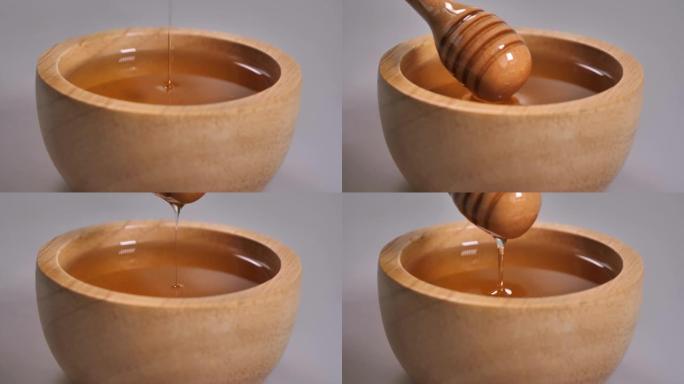 用金属勺子在木碗中取蜂蜜