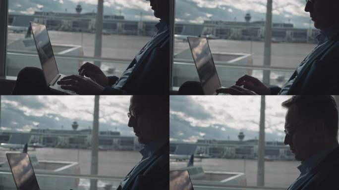 商人在机场等候时使用笔记本电脑