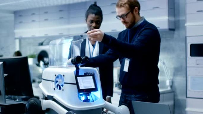 黑人女性和白人男性工程师共同从事机器人项目。他们在一个现代化的实验室里。