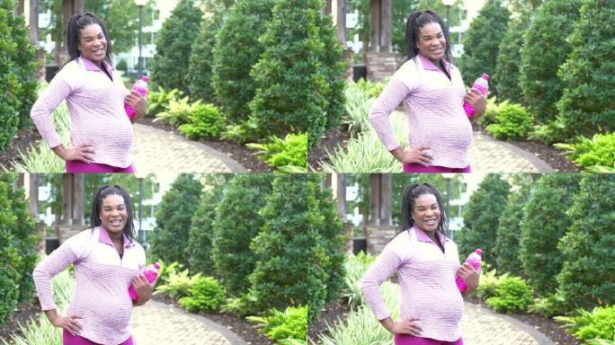 怀孕的非洲裔美国妇女站着，手放在臀部上