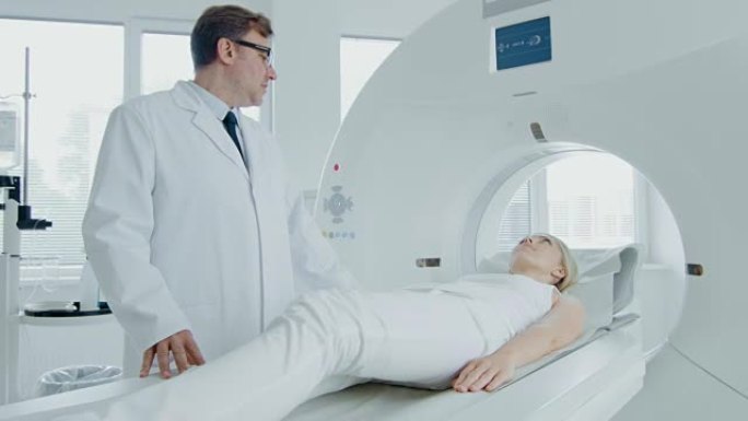 在医学实验室中，男性放射科医生对接受手术的女性患者进行MRI或ct扫描。高科技现代医疗设备。高架摄像