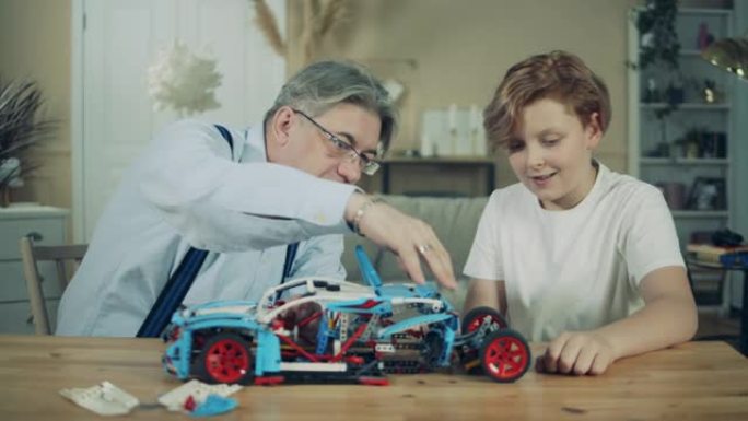 爷爷和他的孙子正在组装一辆玩具车