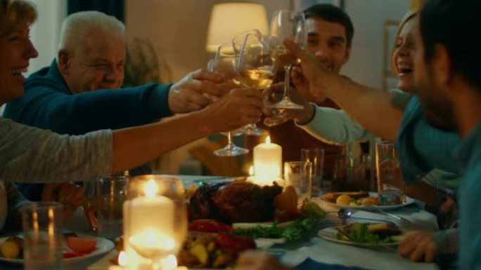 晚上: 家人和朋友聚集在餐桌旁。老人和年轻人玩得开心，吃，喝。他们举杯敬酒。舒适的客厅氛围。