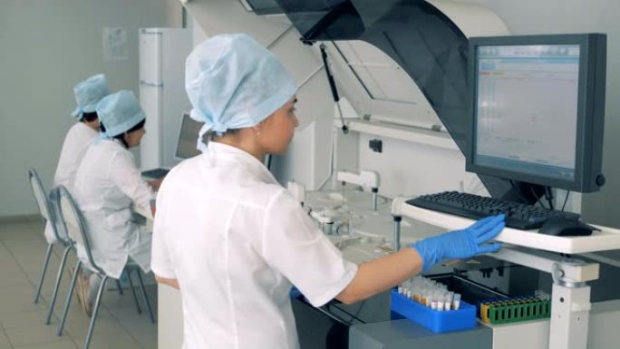护士在现代自动化医疗设备上管理测试过程。