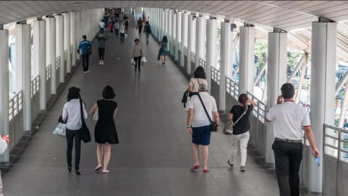 曼谷BTS Chong Nonsi高峰时段，拥挤的匿名人士在高架地铁系统站的立交桥上行走，交通和乘客