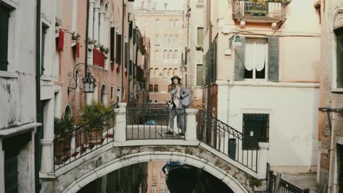 意大利威尼斯水上运河街桥上的摄像机，女性游客的美丽透视图。