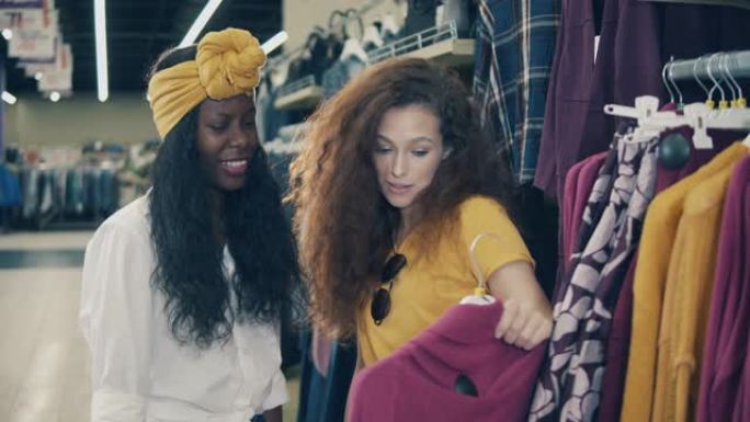 两名年轻女子正在商店里谈论一件衣服