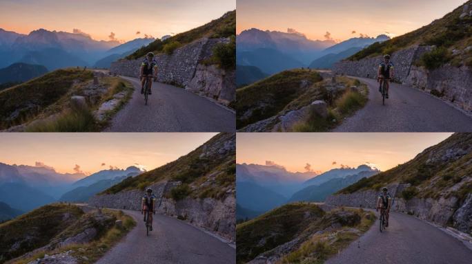 在美丽的夏夜，人路骑自行车上山，背景是分层的山脉