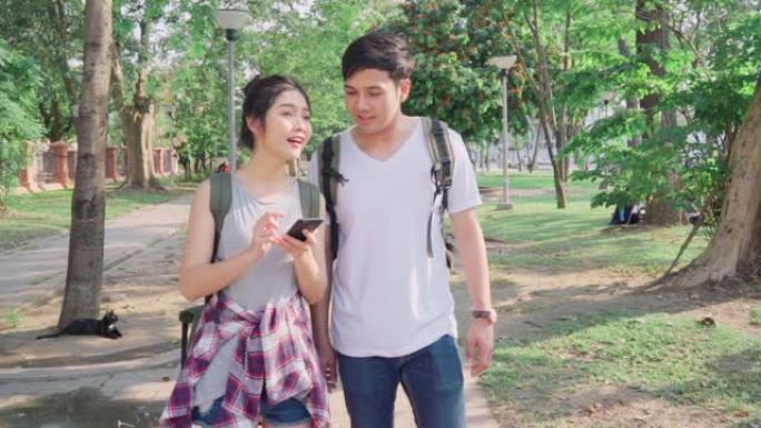 慢动作-旅行者亚洲夫妇在泰国曼谷的位置地图上的方向，夫妇在度假旅行时使用手机在地图上寻找地标。生活方