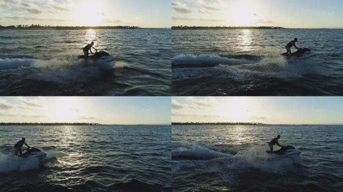4k鸟瞰图，男子在海洋中乘坐私人船只玩得开心，太阳落到海浪上，莫桑比克