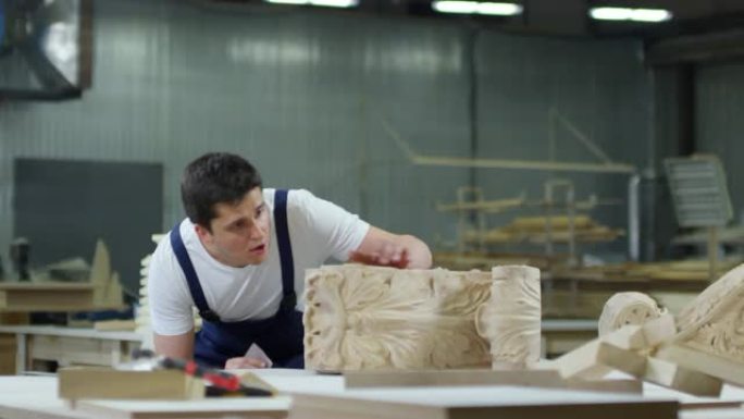 年轻的木匠工作车间工作室面对镜头微笑雕刻