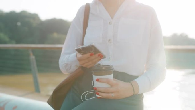 女士无法辨认的女商人使用智能手机，带走咖啡