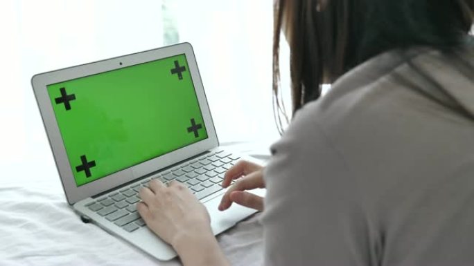 女人使用带有模拟绿屏的笔记本电脑