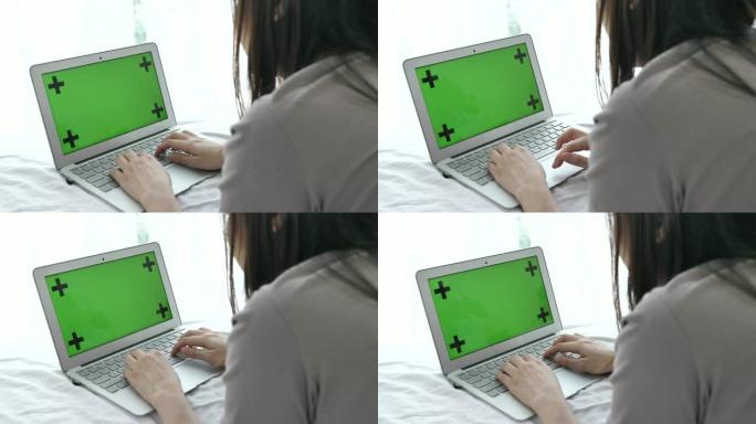 女人使用带有模拟绿屏的笔记本电脑