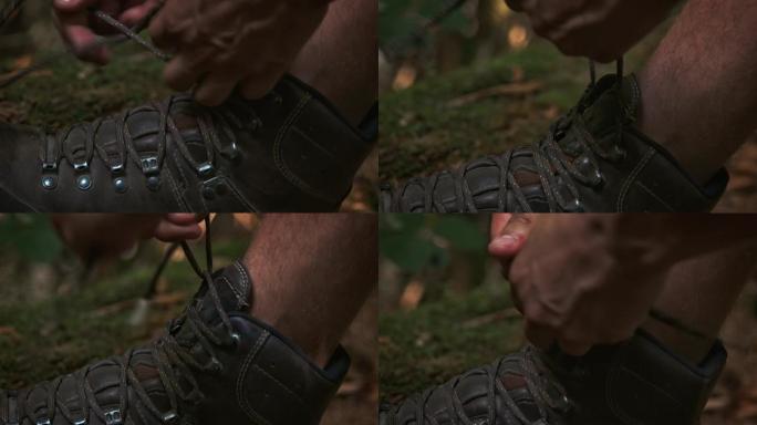 男人在森林里绑着登山靴的花边