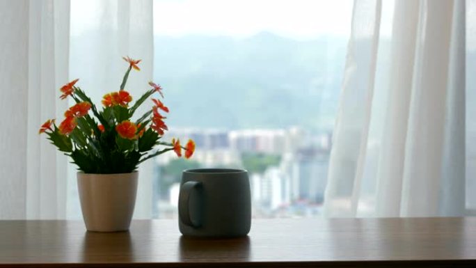 窗帘旁的桌子上的一杯咖啡和花