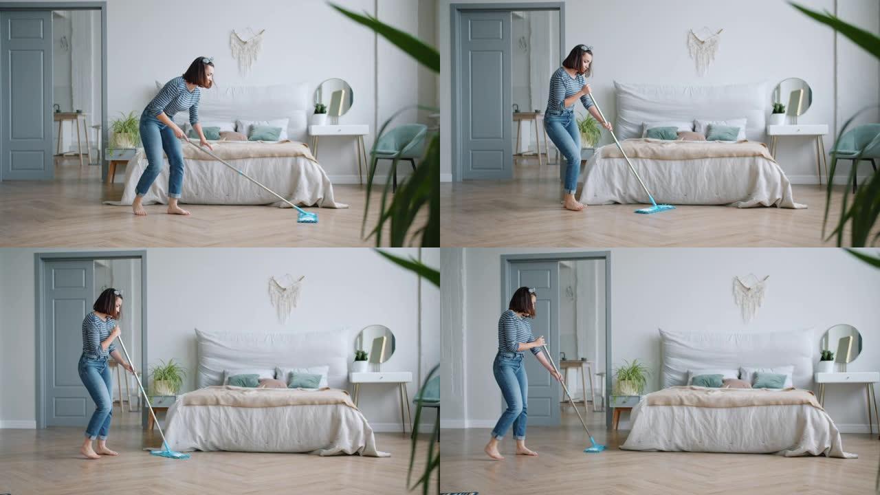 创意女孩在家卧室用拖把唱歌跳舞洗地板