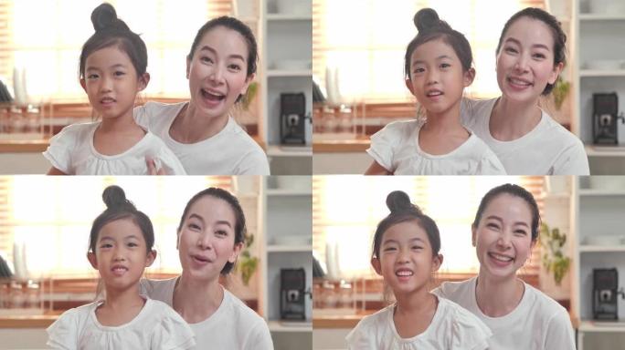 幸福的家庭，6岁的亚洲母亲和女儿在社交距离中一起看着摄像机进行视频通话呆在家里预防冠状病毒或新冠病毒