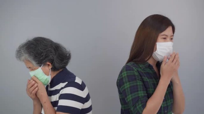 老妇人和女儿戴着口罩咳嗽