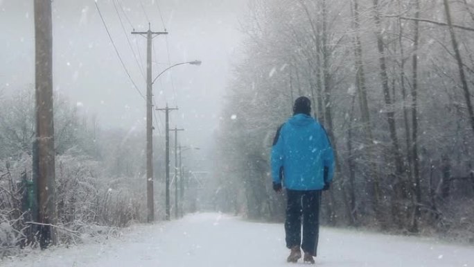 男子在雪地上行走雪天行走下雪天