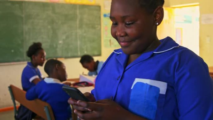 在乡镇学校的教室里使用智能手机的女学生4k