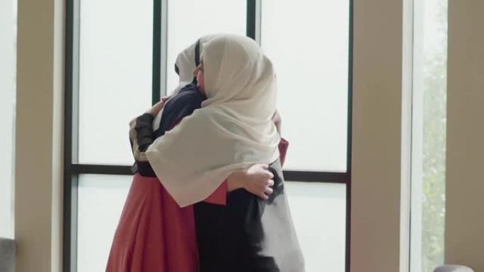 慢动作: 穆斯林妇女问候她的朋友并微笑着交谈