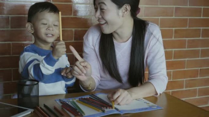 4k镜头的亚洲单亲妈妈和儿子在现代阁楼房屋中微笑着充满幸福的生活，以实现自我学习或家庭学校，家庭和童